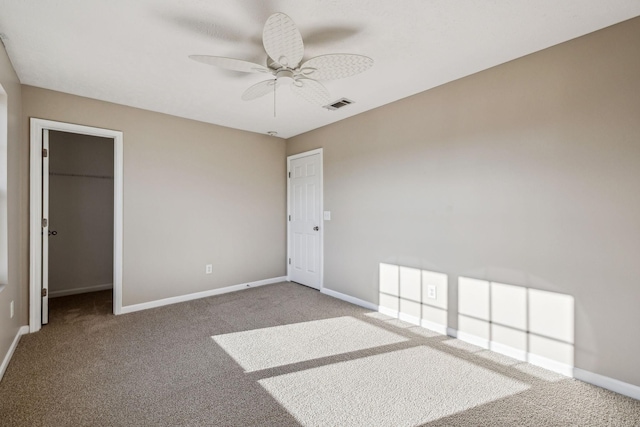 unfurnished room with carpet floors, a ceiling fan, visible vents, and baseboards