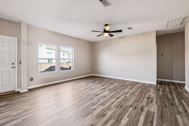 unfurnished room with visible vents, baseboards, and wood finished floors