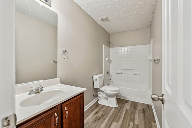 full bathroom with visible vents, toilet, a textured ceiling, vanity, and wood finished floors