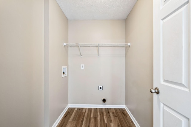 clothes washing area featuring hookup for a washing machine, dark wood-type flooring, electric dryer hookup, laundry area, and baseboards