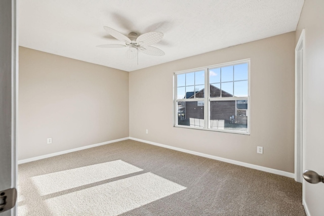 carpeted empty room with baseboards and a ceiling fan