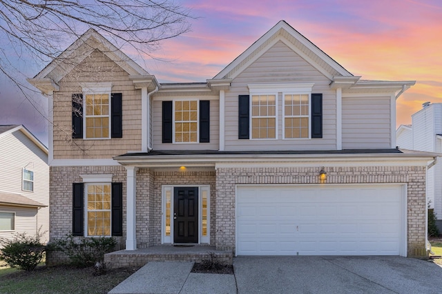 view of front of home with driveway, a garage, and brick siding