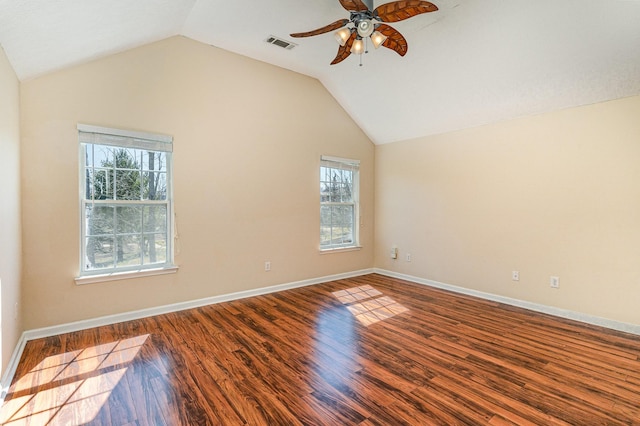 spare room with lofted ceiling, wood finished floors, visible vents, and baseboards