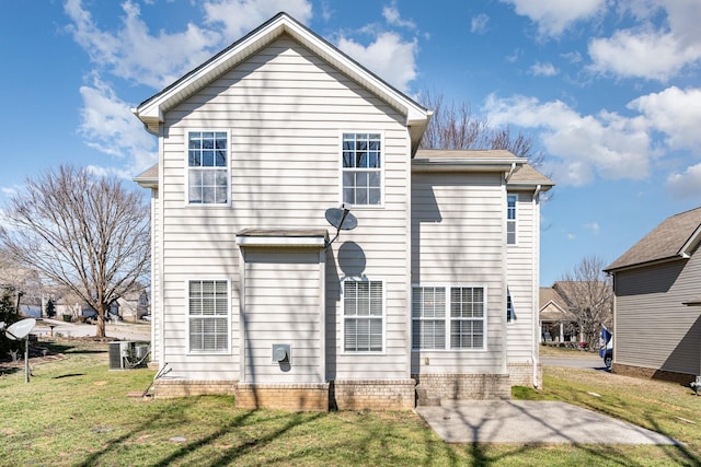 back of house with central air condition unit, a lawn, and a patio