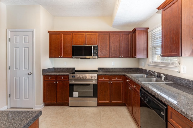 kitchen with light tile patterned floors, stainless steel appliances, a sink, a textured ceiling, and baseboards