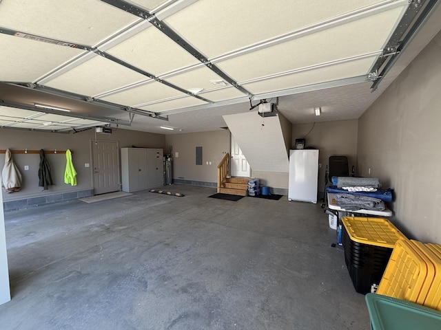 garage featuring electric panel, a garage door opener, and refrigerator