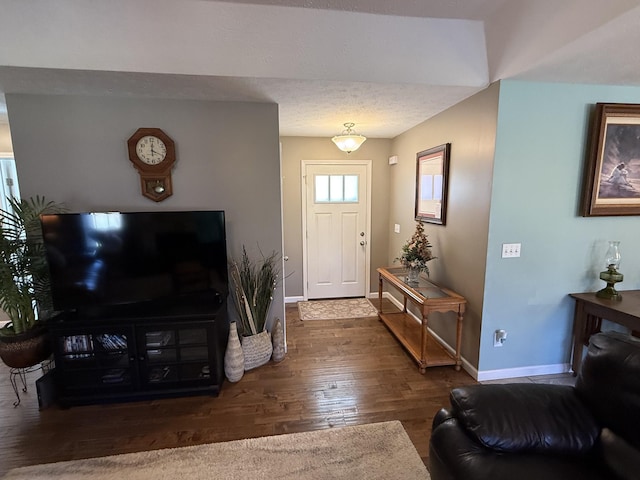 foyer with a textured ceiling, baseboards, and wood finished floors