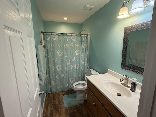 full bath featuring visible vents, toilet, a shower with curtain, wood finished floors, and vanity