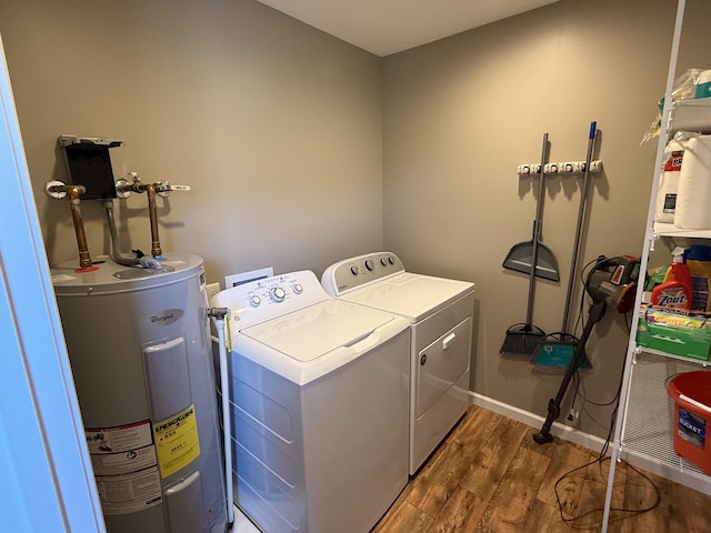 washroom with laundry area, wood finished floors, baseboards, water heater, and washing machine and clothes dryer