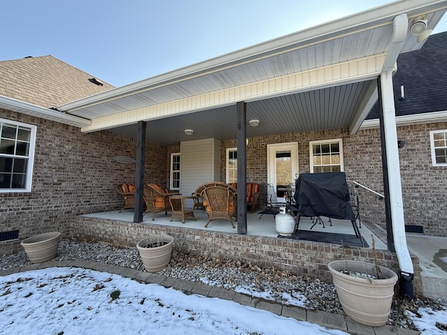 snow covered patio featuring a grill