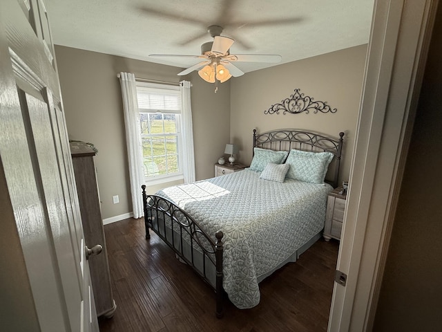 bedroom featuring dark wood-type flooring, ceiling fan, and baseboards