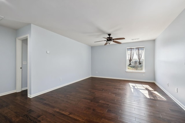 unfurnished room with ceiling fan, dark wood-style flooring, visible vents, and baseboards