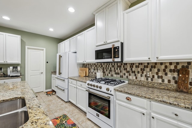 kitchen featuring white appliances, white cabinets, and tasteful backsplash