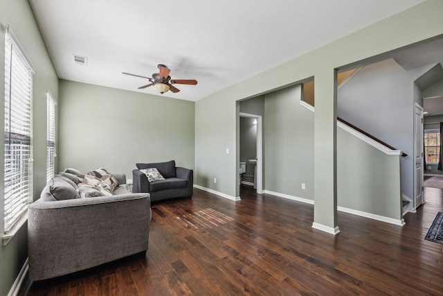 living area featuring baseboards, visible vents, a ceiling fan, stairway, and hardwood / wood-style floors