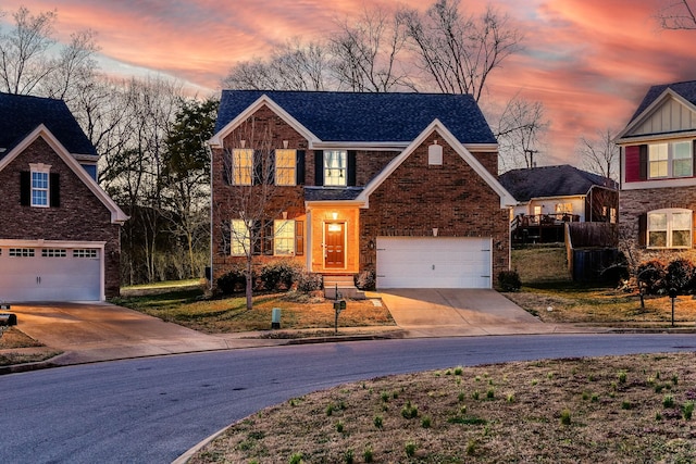 traditional home featuring an attached garage, brick siding, and driveway