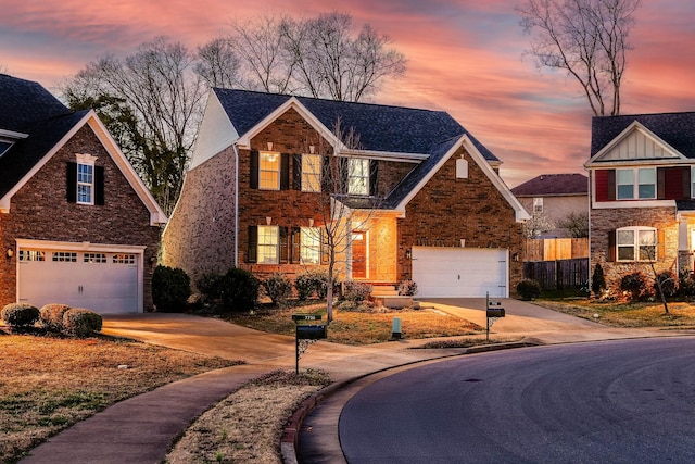 traditional-style home with concrete driveway, an attached garage, fence, and stone siding