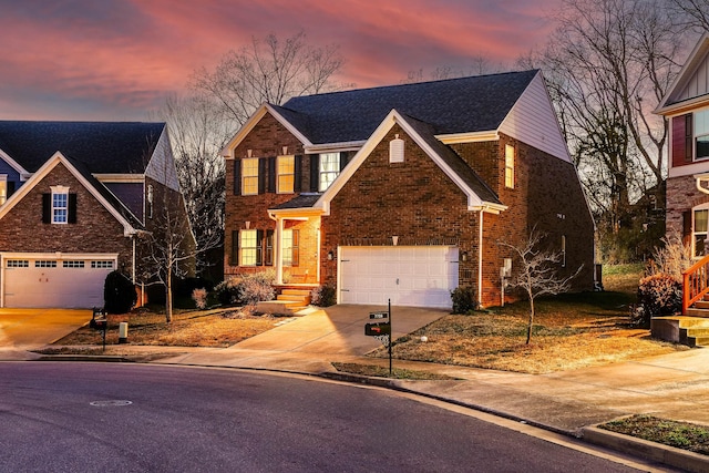 traditional-style home featuring a garage, brick siding, and driveway