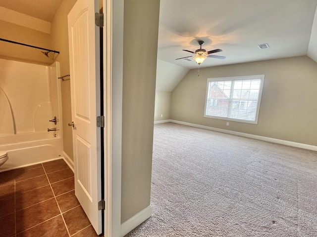 bonus room featuring lofted ceiling, baseboards, visible vents, and dark carpet