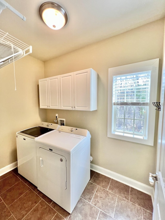 clothes washing area featuring cabinet space, tile patterned flooring, baseboards, and washing machine and clothes dryer