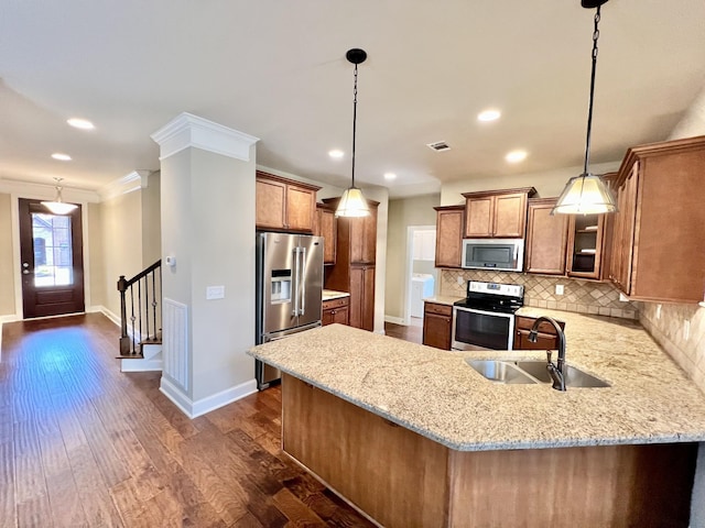 kitchen with brown cabinets, a peninsula, stainless steel appliances, and a sink