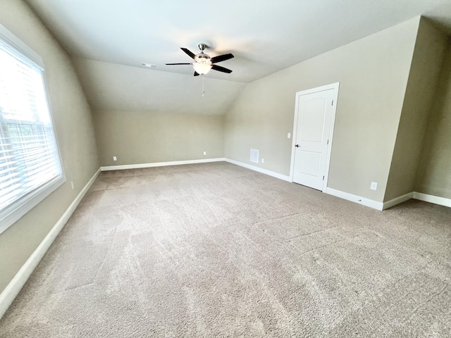 additional living space with carpet, lofted ceiling, visible vents, ceiling fan, and baseboards