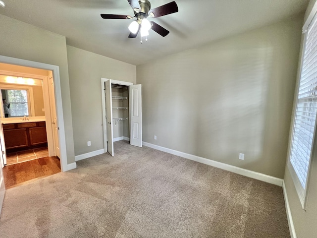 unfurnished bedroom with baseboards, a closet, a ceiling fan, and light colored carpet