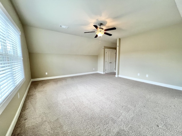 additional living space featuring carpet floors, baseboards, visible vents, and lofted ceiling