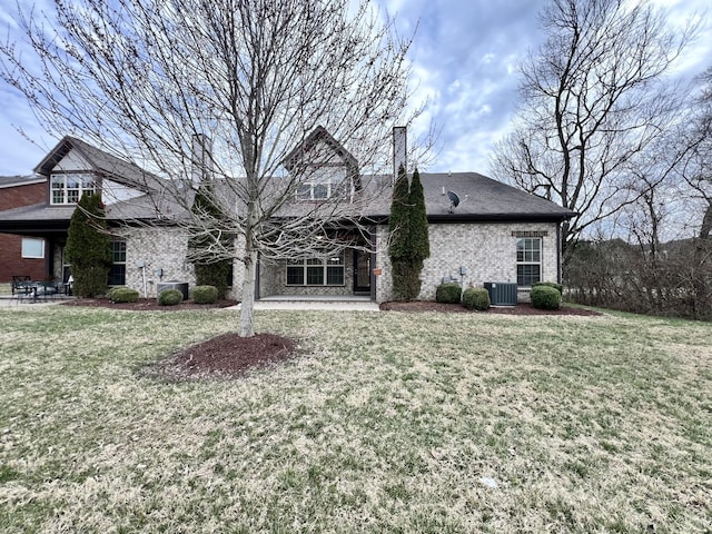 rear view of property featuring a lawn, central AC, and a patio