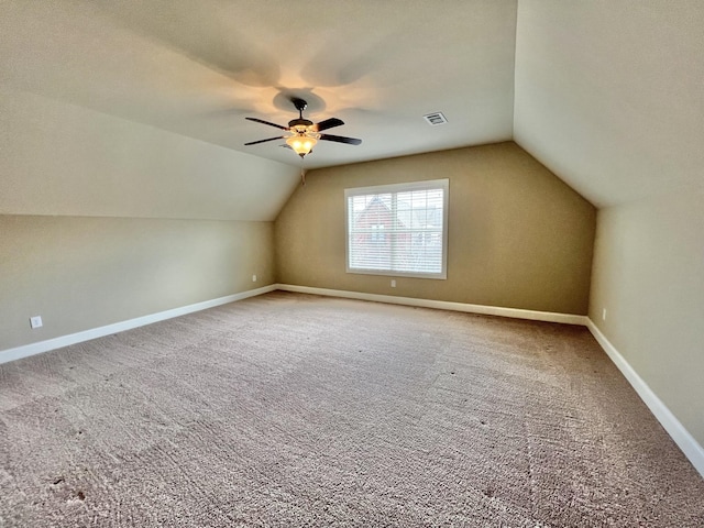 bonus room featuring lofted ceiling, carpet floors, visible vents, and baseboards