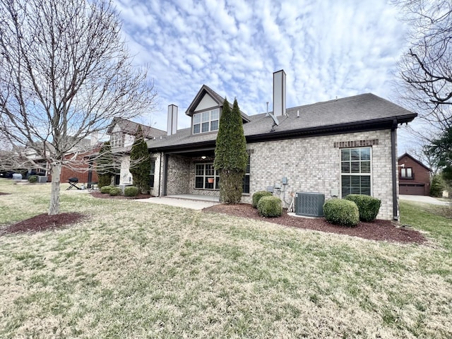 back of house with central AC, a lawn, and brick siding