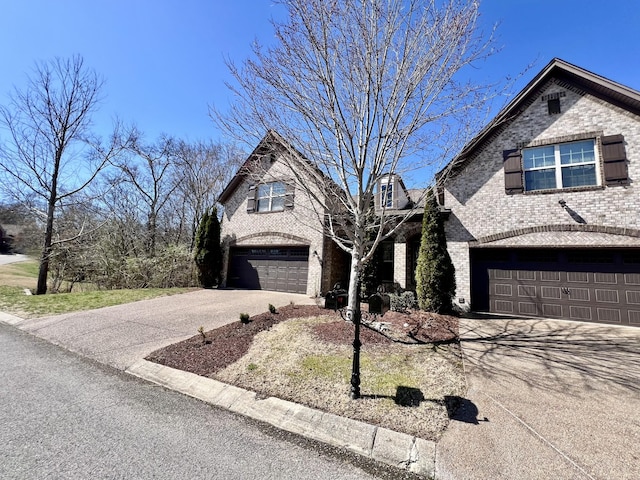 view of front of property with driveway, brick siding, and an attached garage