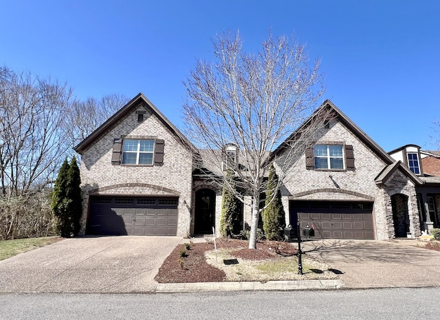 french country style house with brick siding, driveway, and a garage