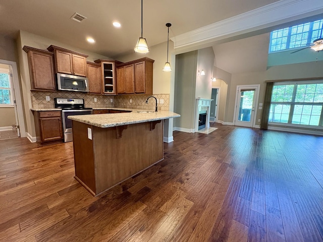 128 Village Cir, Lebanon, TN 37087 - kitchen featuring stainless steel appliances, a sink, a peninsula, glass insert cabinets, and hanging light fixtures