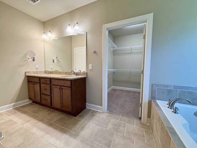 128 Village Cir, Lebanon, TN 37087 - bathroom featuring double vanity, a bath, baseboards, a walk in closet, and tile patterned floors