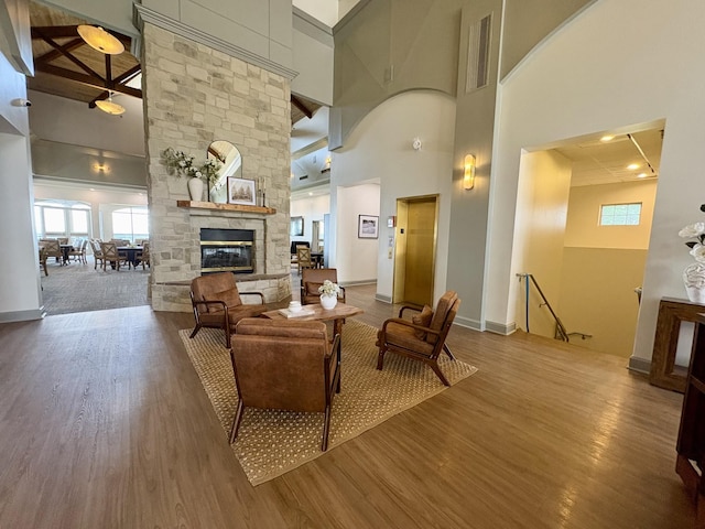 128 Village Cir, Lebanon, TN 37087 - living area with wood finished floors, a towering ceiling, healthy amount of natural light, a stone fireplace, and baseboards