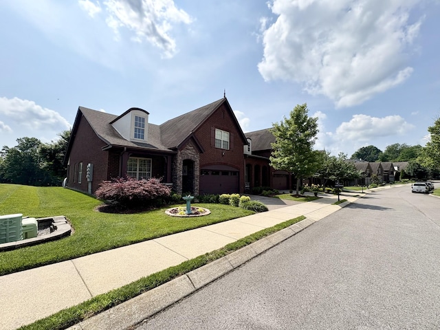 128 Village Cir, Lebanon, TN 37087 - view of front of property with a garage, driveway, brick siding, and a front yard