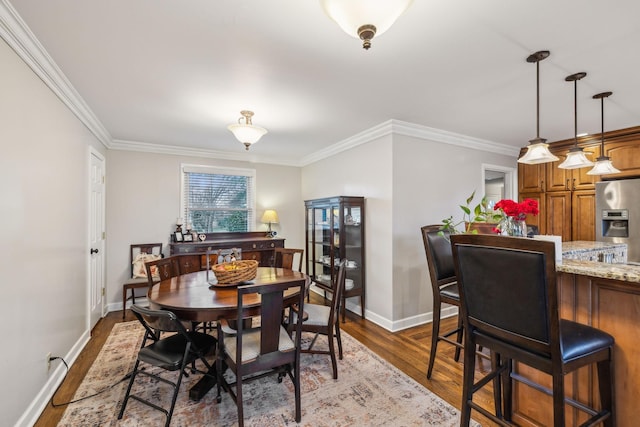 dining room featuring dark wood-style floors, baseboards, and crown molding