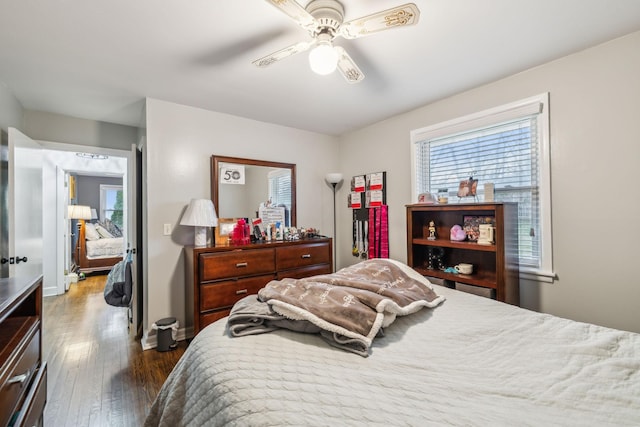 bedroom featuring a ceiling fan, wood-type flooring, and baseboards