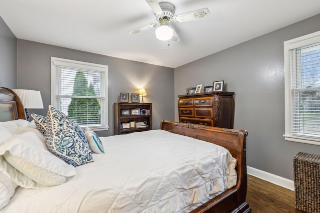 bedroom with dark wood-style floors, multiple windows, baseboards, and a ceiling fan