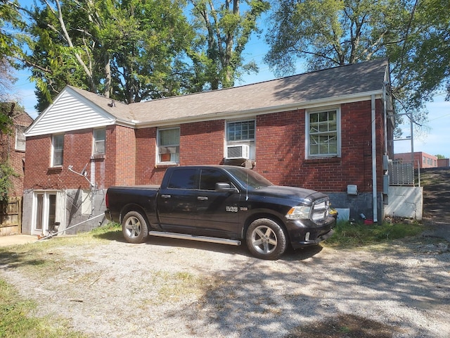 view of front facade with cooling unit and brick siding