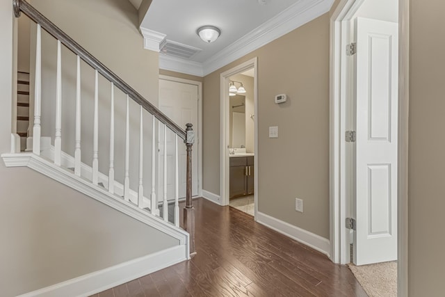 foyer featuring baseboards, visible vents, wood finished floors, stairs, and crown molding