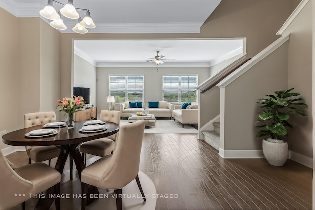 dining room featuring ceiling fan with notable chandelier, baseboards, stairs, ornamental molding, and hardwood / wood-style floors