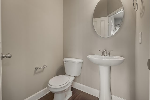 bathroom with wood finished floors, toilet, and baseboards