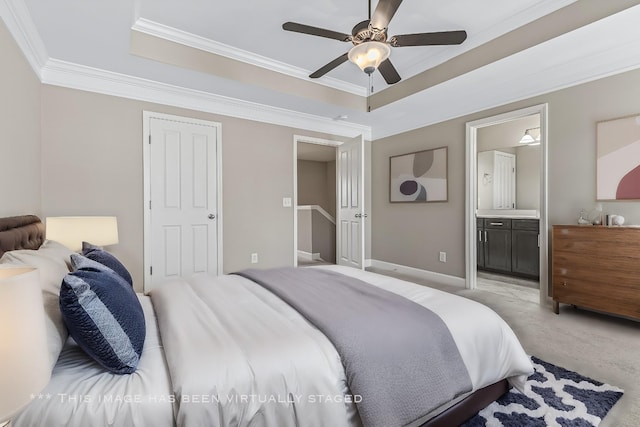 bedroom with ensuite bathroom, a raised ceiling, crown molding, and light colored carpet