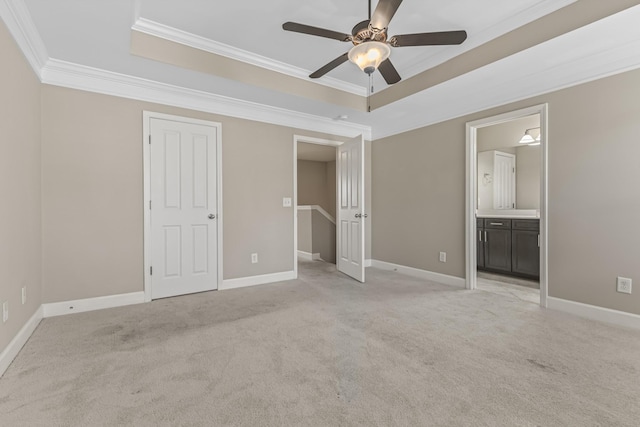 unfurnished bedroom featuring a raised ceiling, crown molding, and light colored carpet