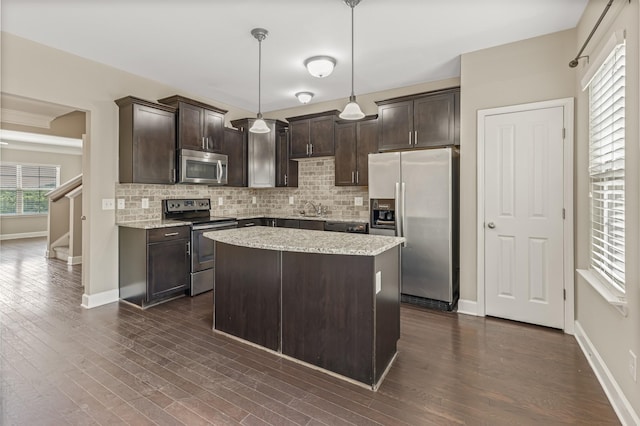 kitchen with dark brown cabinets, appliances with stainless steel finishes, backsplash, and a sink