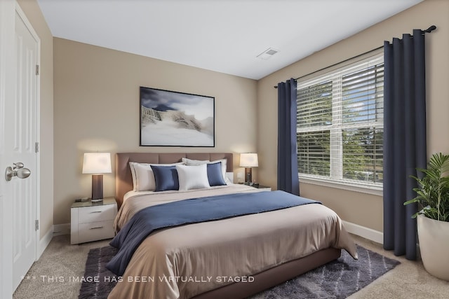 bedroom with carpet floors, visible vents, and baseboards