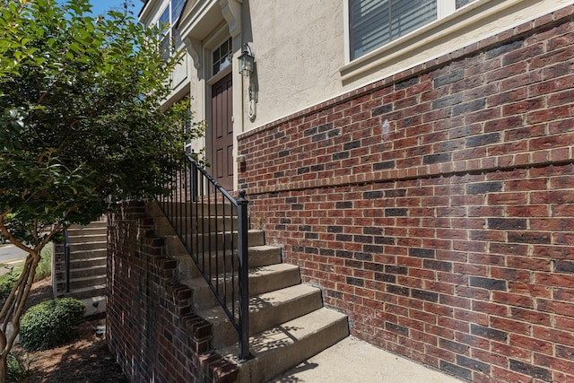 property entrance featuring brick siding and stucco siding