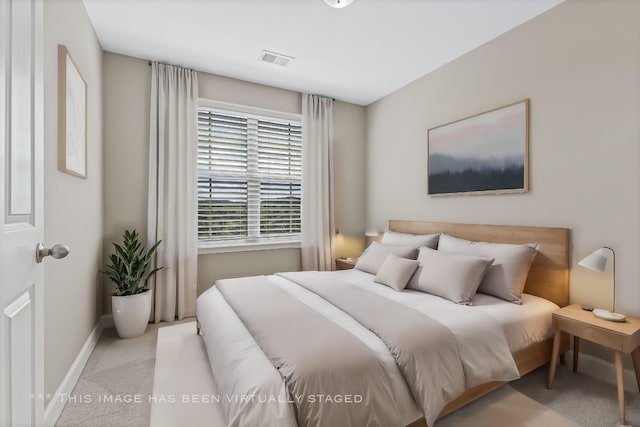 bedroom with baseboards, visible vents, and light colored carpet