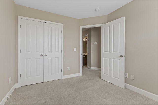 unfurnished bedroom with carpet floors, a closet, and baseboards